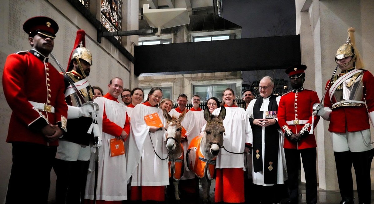 Choir and military guards with donkeys at Brooke's carol service 