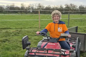 Woman on tractor at stables