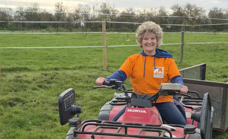Woman on tractor at stables